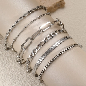 Set aus sechs silbernen Edelstahl-Armbändern minimalistisch auf Schmuckständer präsentiert