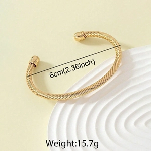 Detail of gold twisted cable open bangle with ball ends, 6cm diameter and 15.7g weight