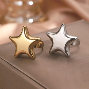 Macro shot of gold and silver star rings displayed on a brown premium velvet jewelry box