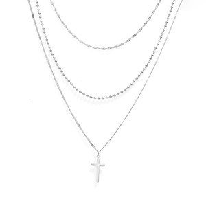 Détail d'un collier multicouche en acier inoxydable argenté avec pendentif croix