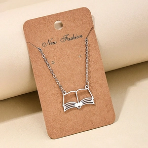 Detail of silver hollow open book pendant necklace on brown kraft card display