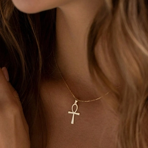Golden Ankh cross necklace in polished stainless steel worn by a model on the neck