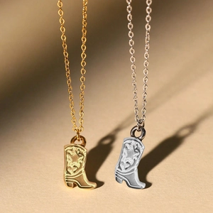 Detail view of gold and silver cowboy boot pendants with intricate star engravings