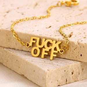 Chaîne de cheville dorée en acier inoxydable avec lettres FUCK OFF sur pierre travertin