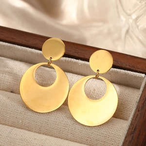 Minimalist gold geometric circle earrings displayed in a luxury wooden jewelry box
