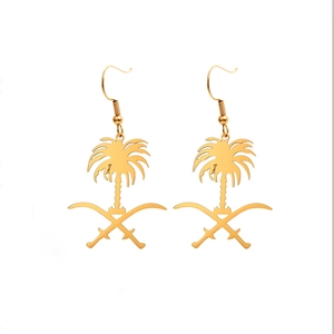 Détail de boucles d'oreilles dorées emblème Arabie Saoudite palmier et sabres