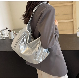Detail of silver metallic tote bag with wrinkled texture and functional side zipper