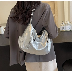 Close-up of silver metallic hobo bag with pleated texture and stylish zipper details