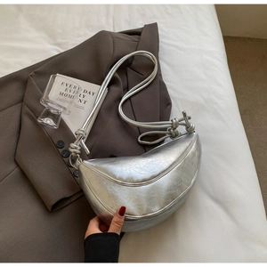 Close-up of silver crescent bag with retro crinkled texture and knot strap details