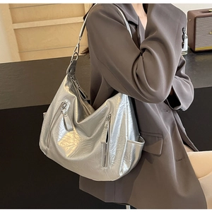 Detail of silver metallic hobo bag with wrinkled texture and functional side zippers