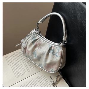 Detail of floral embroidery on beige jacquard handbag with silver metallic handle