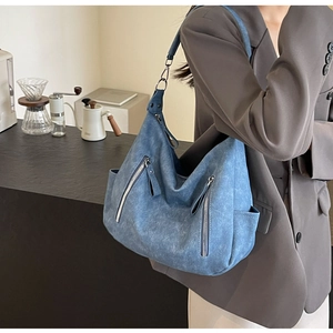 Detail of blue oversized tote bag with distressed texture on a cafe background
