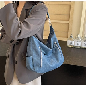 Detail of vintage blue matte leather tote bag with multi-pocket and industrial Hobo design