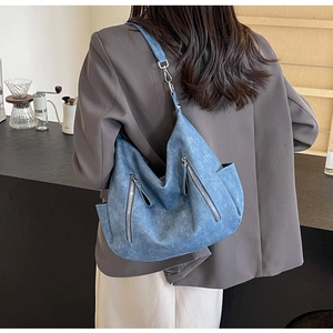 Detail view of large blue vintage tote bag with side zippers and wide shoulder strap