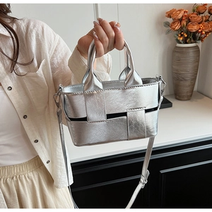 Detail of silver woven handbag showing metallic texture and adjustable shoulder strap
