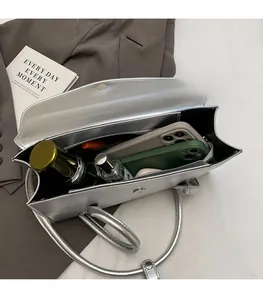 Detail view of the spacious silver handbag interior with compartment for essentials
