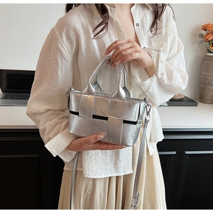 Detailed macro view of the silver woven metallic handbag with shiny leather texture