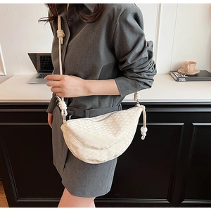 Détail du sac bandoulière croissant tissé beige avec bandoulière corde et nœud chic
