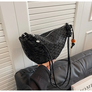 Détail du sac hobo noir à paillettes avec bandoulière tressée et perle ambre