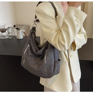 Detail of vintage charcoal grey tote bag with silver zippers shown on a model