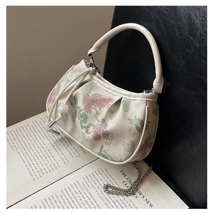 Detail of floral embroidery and pearl drawstring on vintage cream pleated crossbody bag