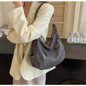 Close-up of matte dark grey tote bag with metallic zipper details and retro biker style