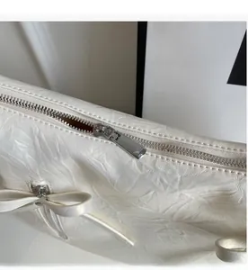 Detail of silver smooth zipper and lychee pattern texture on white bucket bag