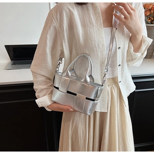 Detail of silver metallic woven mini tote bag shown with elegant office wear