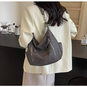 Detailed back view of a grey crescent hobo bag with silver zippers and adjustable strap