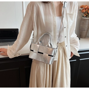 Detail of silver woven tote bag with adjustable strap and textured metallic finish
