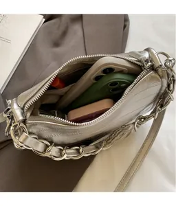 Vue de dessus d'un sac bandoulière argenté montrant la capacité et le détail du zip