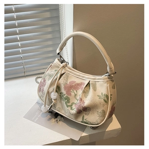 Detail of floral embroidery and pearl drawstring on vintage cream shoulder bag