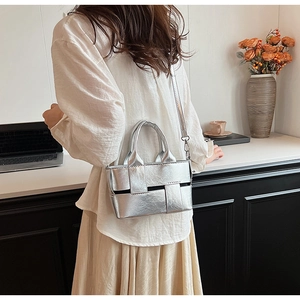 Detail of silver woven leather tote bag with metallic finish and detachable strap