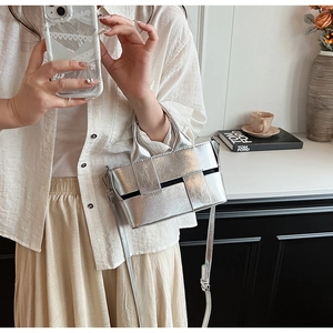 Detail of silver metallic woven handbag showing intricate texture and luxury finish
