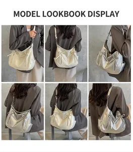 Detail view of a silver bucket bag with bow accents and adjustable strap on a model