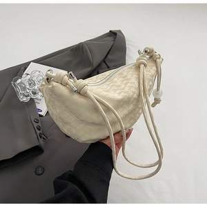 Détail du sac demi-lune blanc cassé avec texture peau de serpent et boucles en argent