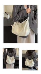 Detail of off-white lychee texture bucket bag with elegant bow zipper and metal strap