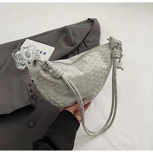 Détail du sac bandoulière croissant gris clair avec texture lune et bandoulière nouée