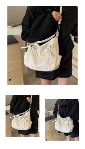Detail of cream bucket bag showing lychee pattern texture and elegant bow decoration
