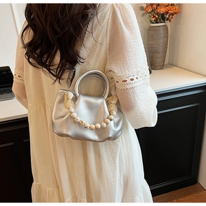 Détail du sac nuage plissé argenté avec chaîne en perles et texture cuir métallisé