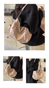 Detail of light pink bucket bag with lychee texture and decorative bow ties and zippers