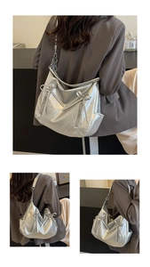 Close-up of silver pleated shoulder bag with bow accents and metallic texture