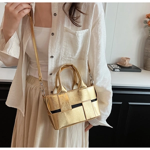 Close-up of golden woven tote bag with metallic finish and adjustable shoulder strap