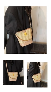Detail of woven straw bucket bag with gold clasp and leather trim on a model