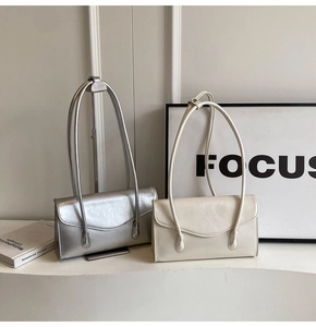 Detail view of silver and cream leather shoulder bags with a minimalist rectangular design