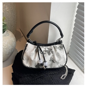 Detailed close-up of embroidered floral handbag with chain strap and bead detail