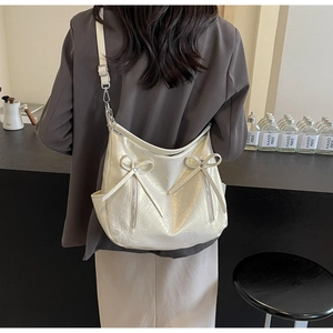 Close-up of cream white hobo bag showing bow detail and silver metal zipper texture