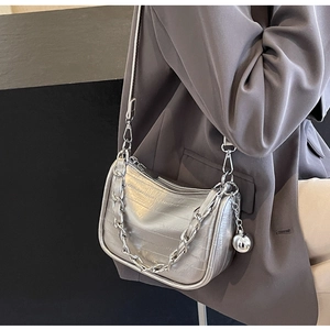 Détail du sac demi-lune argenté effet crocodile avec grosse chaîne et breloque boule