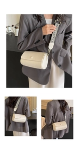 Detail view of cream beige cylinder crossbody bag with geometric woven shoulder strap