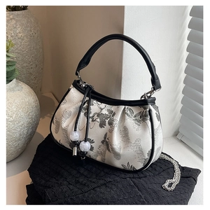Detail of floral embroidery and bead tassel on cream-white Chinese style crossbody bag